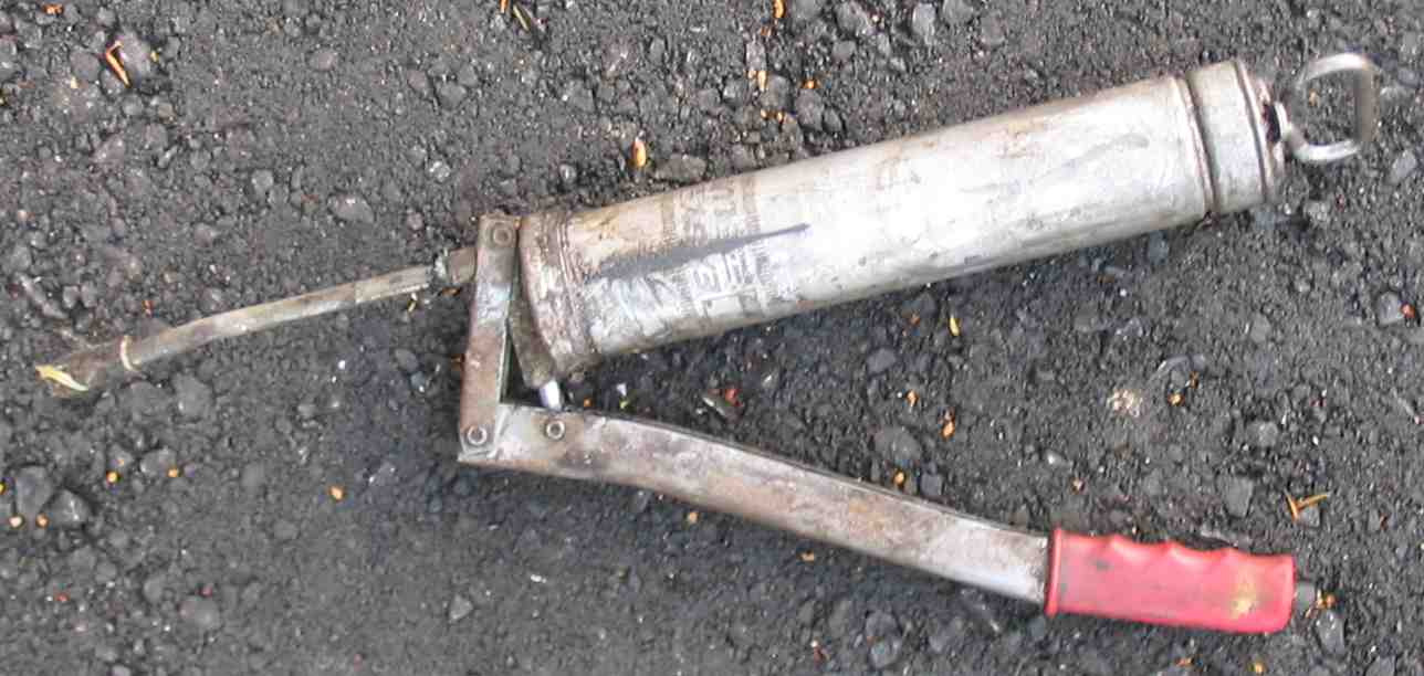 2004年手動潤滑脂加注器實拍；原圖為挖土機附件工具，不推定所有軸承使用相同補脂程序。