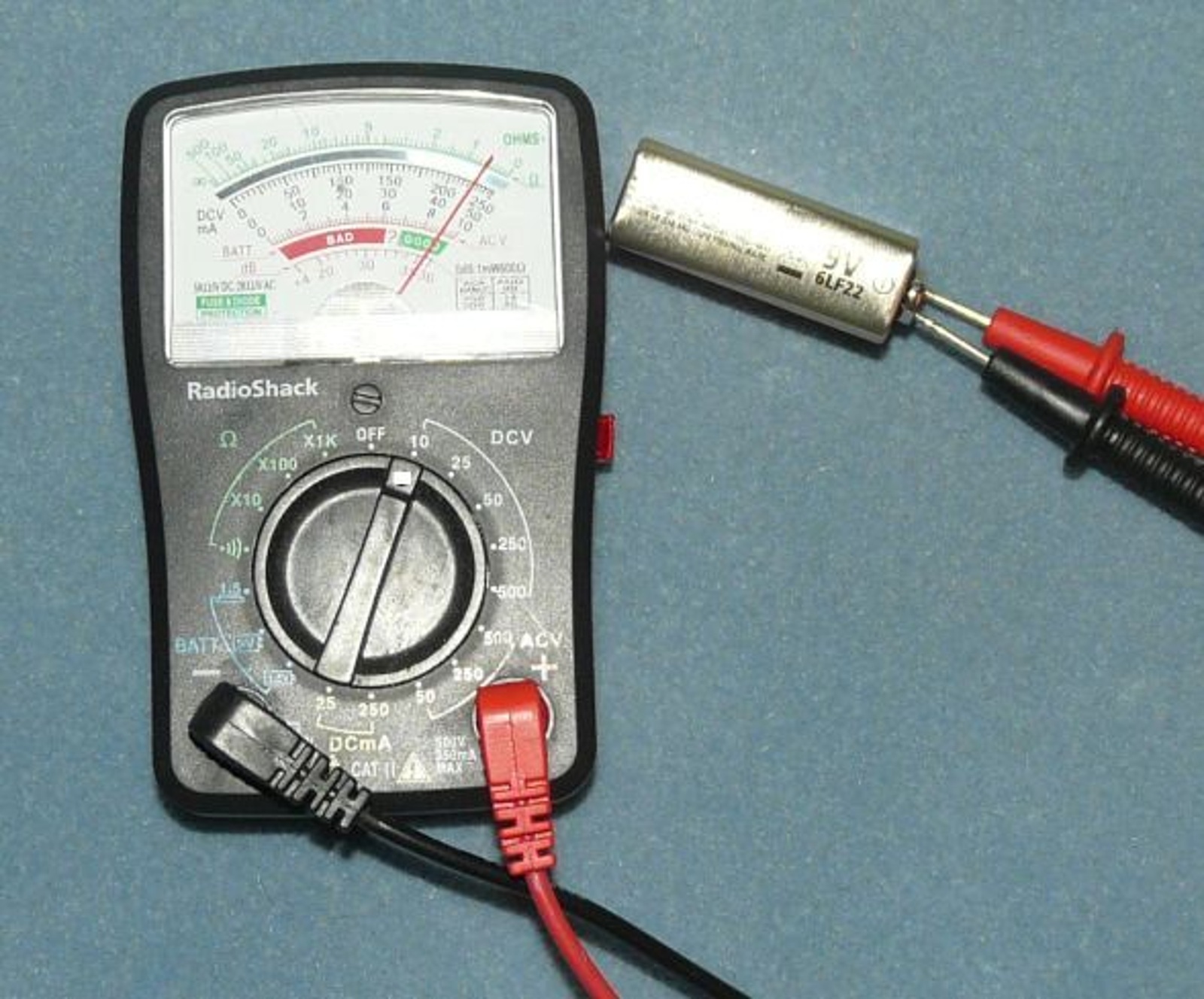 萬用電錶與一般電池的實拍範例；不是機車電瓶量測，不代表已完成充電或起動能力檢測。